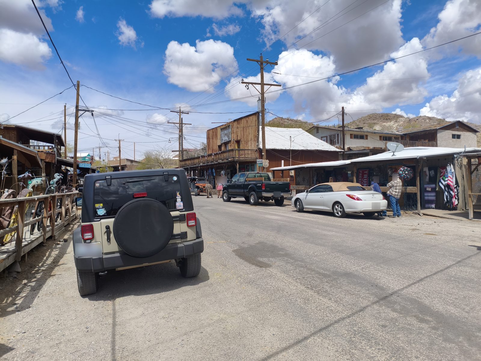 Rue principale d'Oatman sur la Route 66, bordée de boutiques en bois, avec un âne au loin