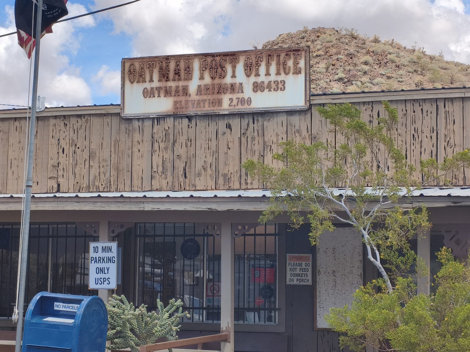 Bureau de poste d'Oatman avec un panneau demandant de ne pas nourrir les ânes sous le porche