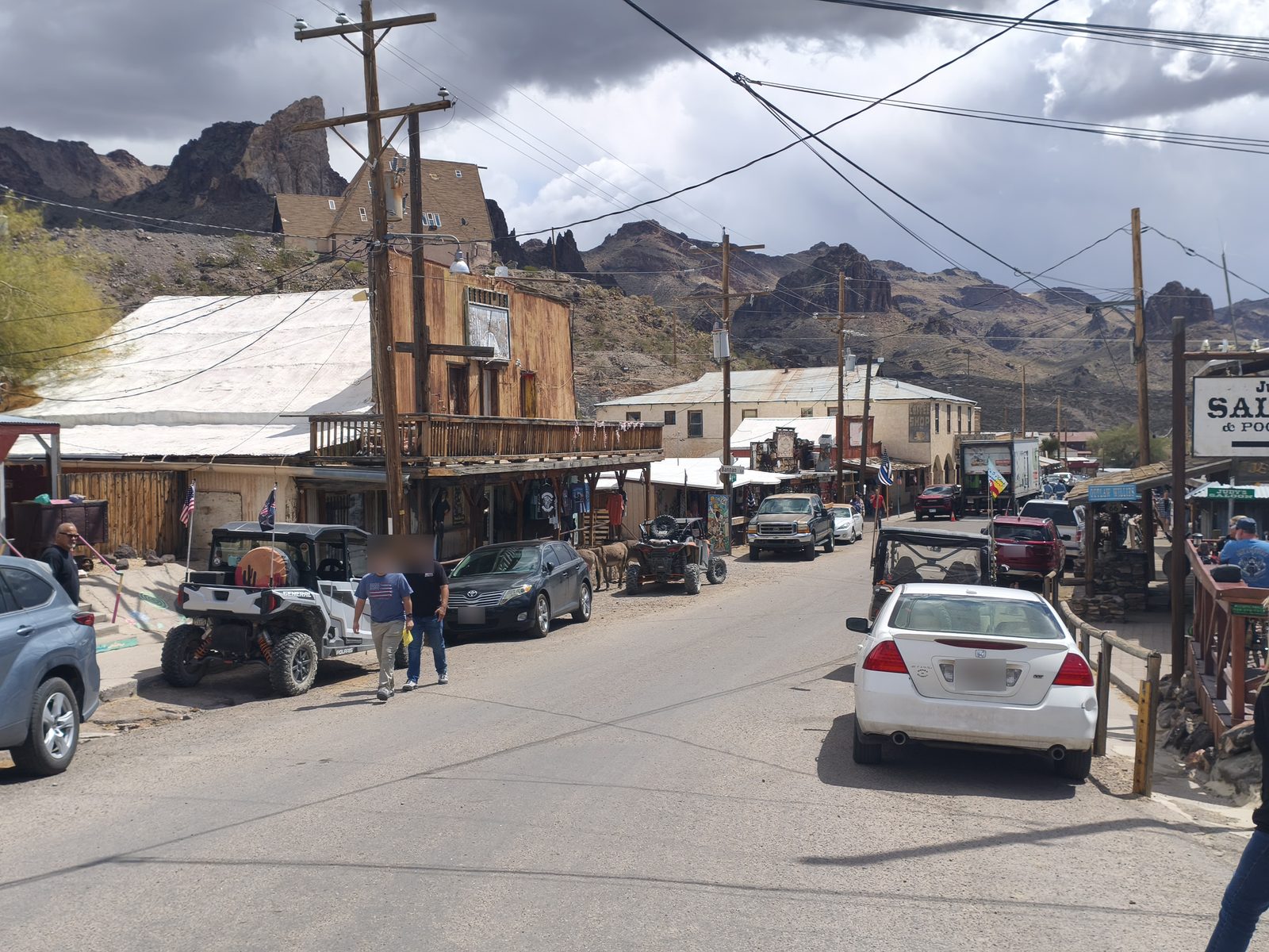 Ânes entre les voitures de la rue principale d'Oatman, avec les Black Mountains en arrière-plan
