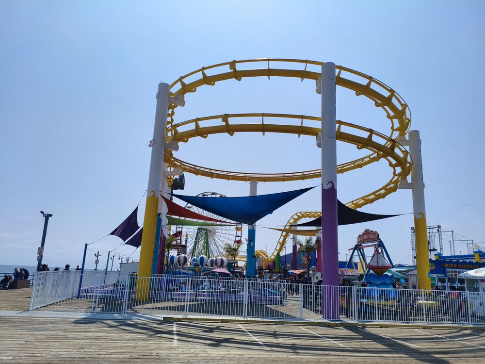 Rails jaunes des montagnes russes de Pacific Park avec la grande roue en arrière-plan
