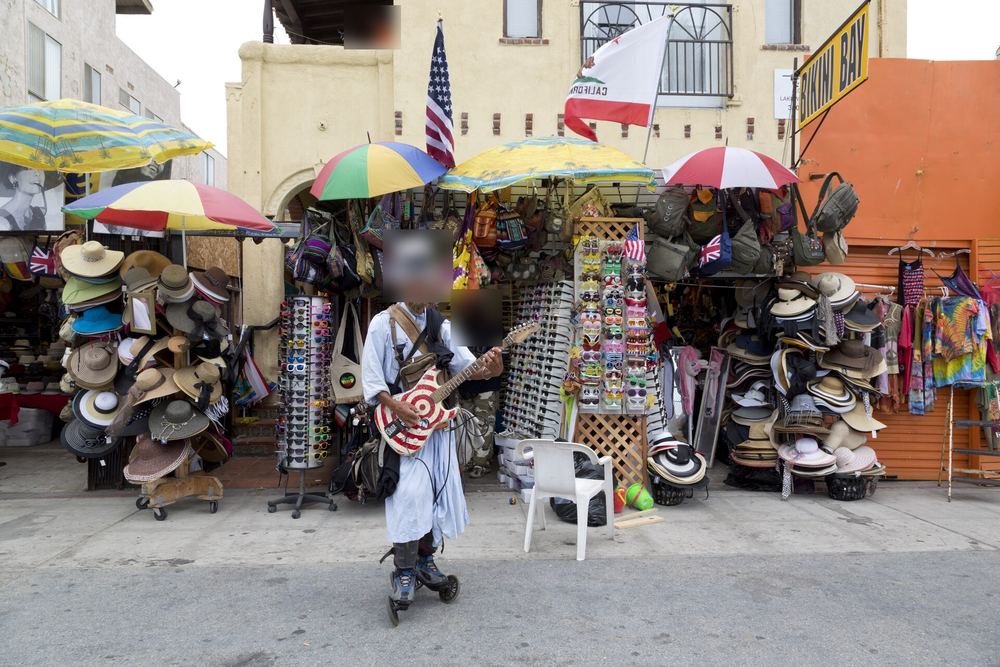 Un artiste de rue et un stand de vendeur sur l'Ocean Front Walk à Venice Beach